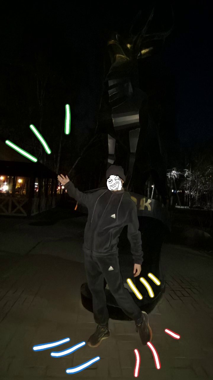 Night photo in a black tracksuit beside a tall dark sculpture